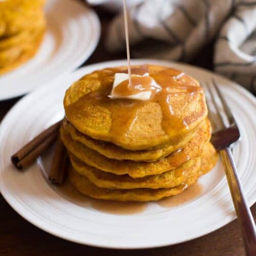 A stack of pumpkin pancakes on a white plate.