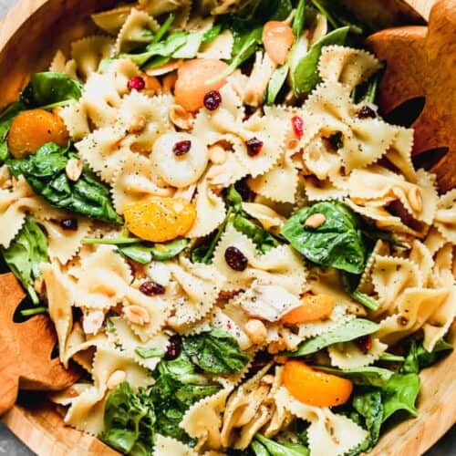 Teriyaki Pasta Salad served in a large wood bowl with wooden tongs.