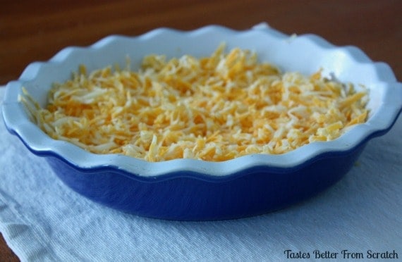A pie dish filled with shredded cheese.