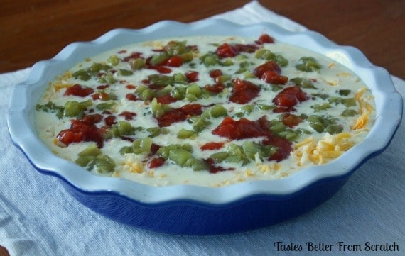 A pie dish filled with uncooked quiche.