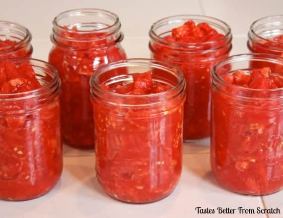 Mason jars filled with canned tomatos.