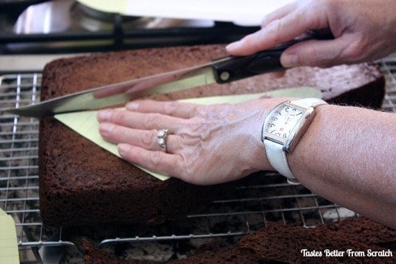 A baked cake being cut into patterns for an airplane cake.