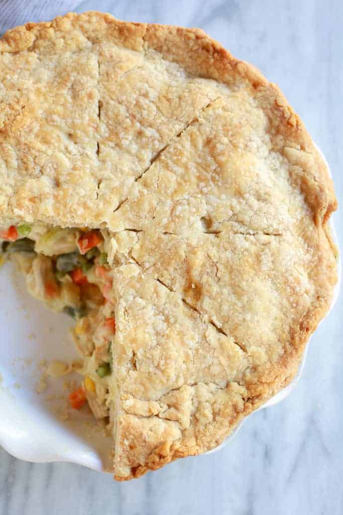 Overhead view of chicken pot pie with a piece taken out.