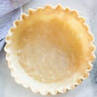 Pie crust with a crimped edge in a pie dish ready to be baked.