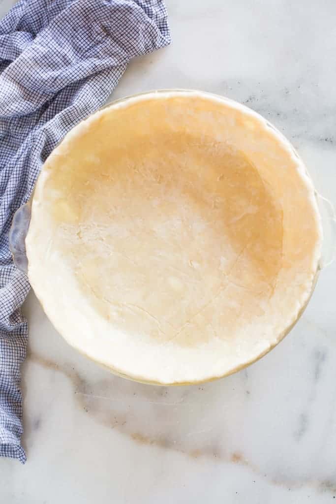 Pie crust in a pie dish ready to be baked.