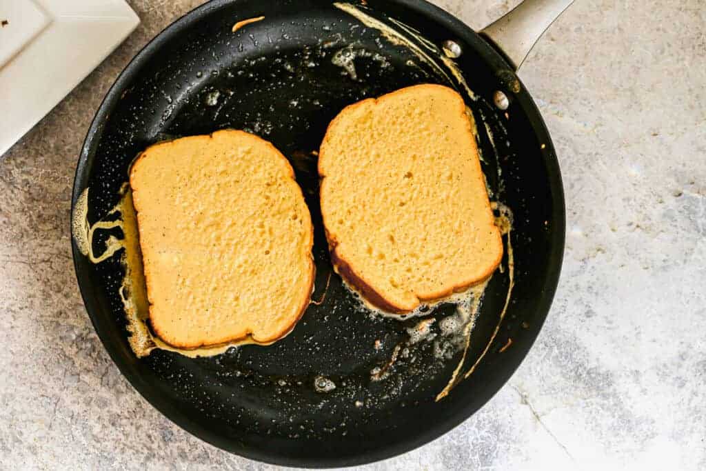 Deux tranches de pain doré cuit dans une poêle.
