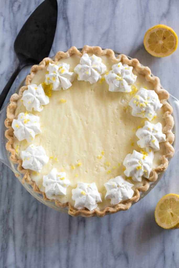 Overhead photo of a lemon chiffon pie with piped whipped cream and lemon zest.