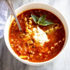 Lasagna Soup with a scoop of ricotta cheese on top and a spoon in the bowl.