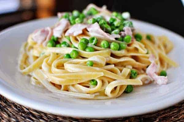Fettuccini with ham and peas on a plate.