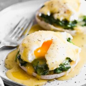 A plate with eggs florentine on it (english muffin topped with spinach, poached egg and hollandaise sauce).