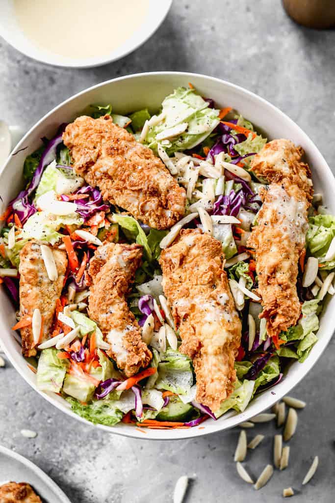 Applebees Chicken Salad in a serving bowl with dressing on top.