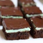 Mint brownies cut into squares and lined on a white tray for serving.