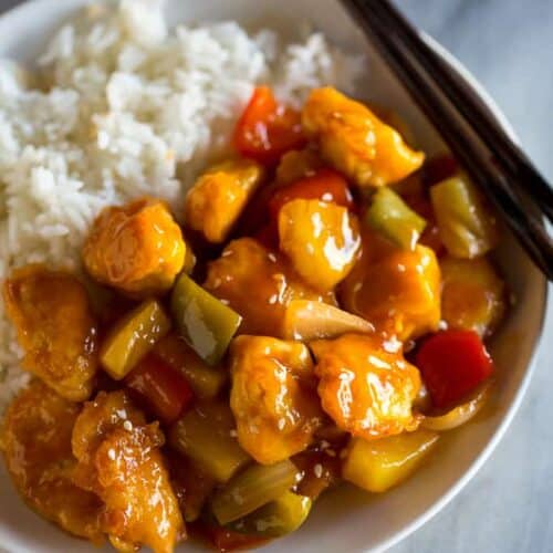 Close-up photo of a plate with sweet and sour chicken and white rice.