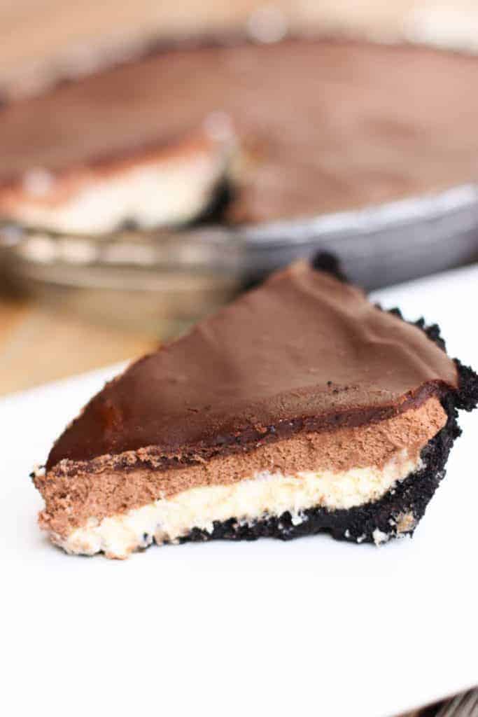 Chocolate mousse cheesecake with an oreo crust, a cheesecake layer topped with chocolate mousse and chocolate ganache.