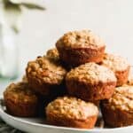Banana Oat Muffins stacked on a plate.