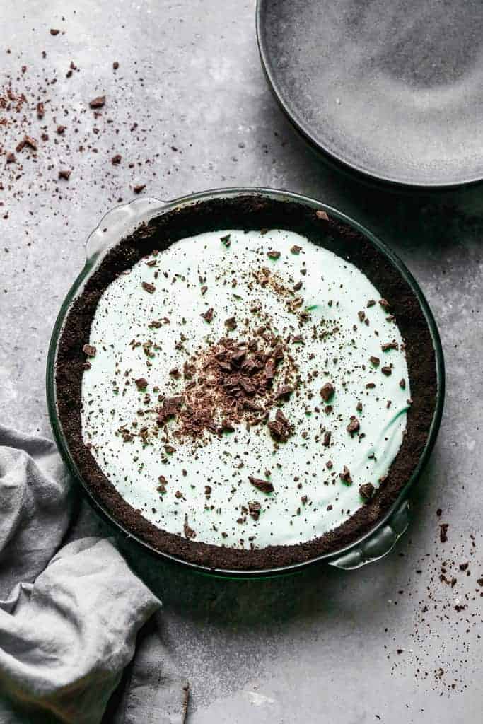 Grasshopper pie in a chocolate cookie crust, garnished with crushed cookie crumbs.