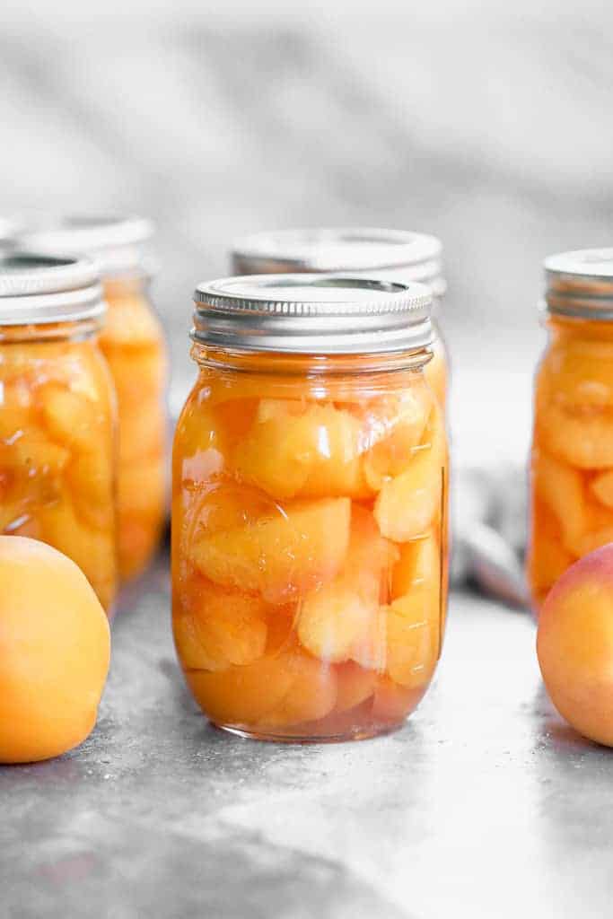 Jars of home canned peaches in quart jars.