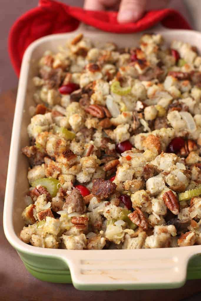 A small casserole dish filled with Sausage Cranberry Pecan Stuffing.