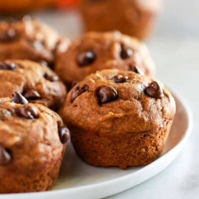 Queques de abóbora saudáveis com pedaços de chocolate, num prato branco.