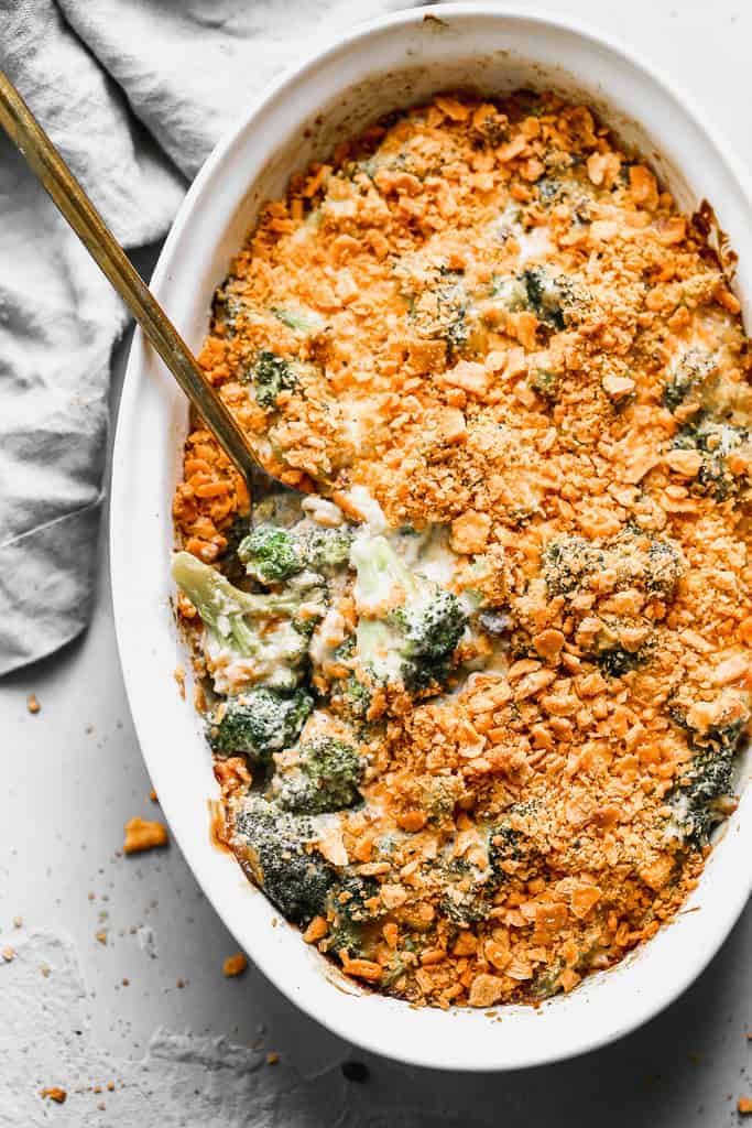 Broccoli Casserole baked in an oval serving dish with a spoon in it, for serving.