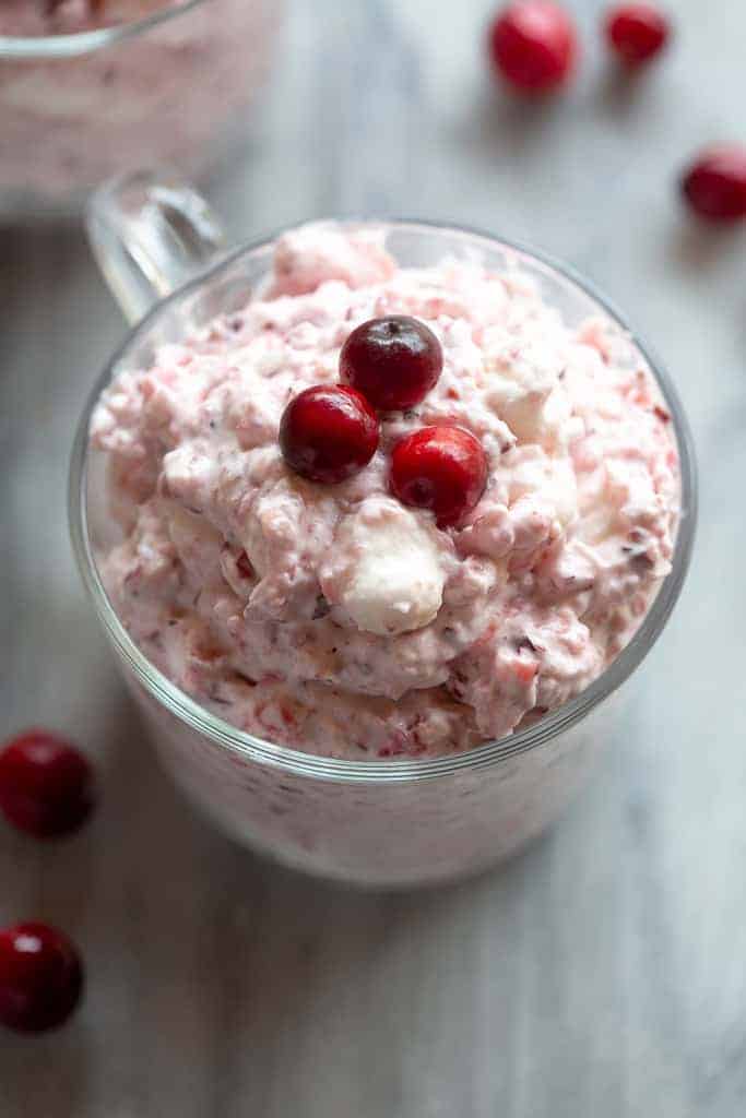Cranberry fluff salad in a cup with a handle.