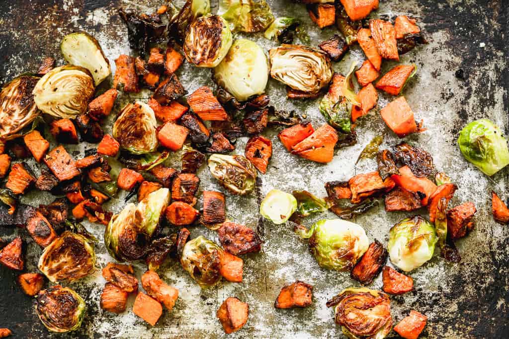 Chopped sweet potato and Brussels sprouts roasted on a sheet pan.