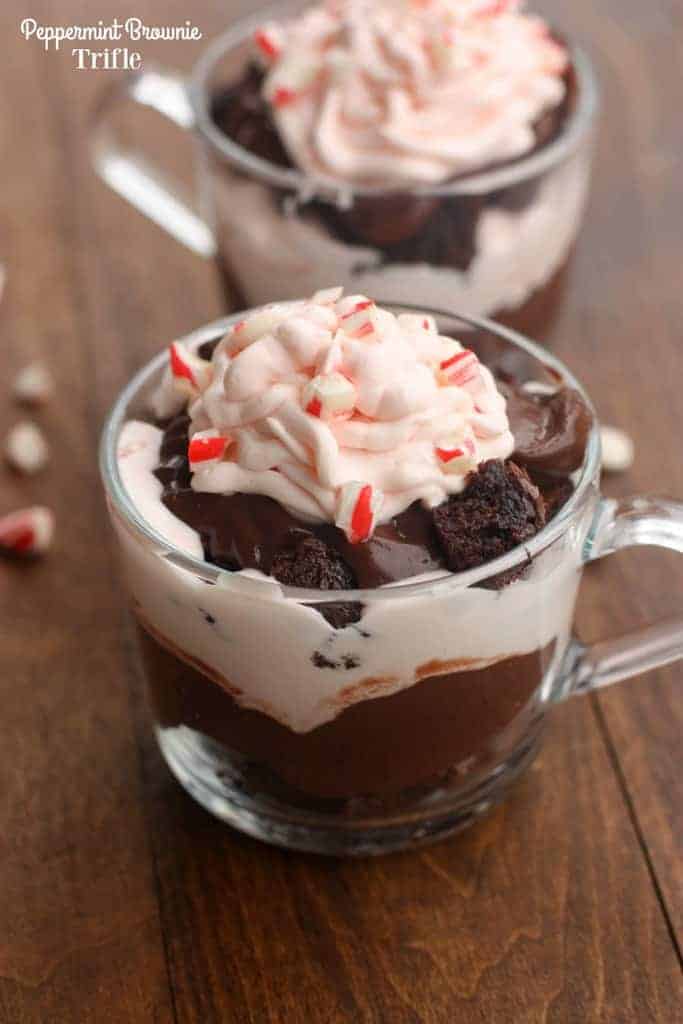 Two small, glass cups filled with layers of brownie, chocolate pudding, and white chocolate peppermint mousse.
