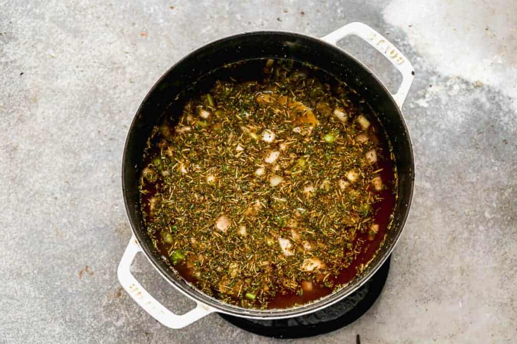 Bouillon de légumes et épices cuits dans une casserole pour faire une soupe de légumes.