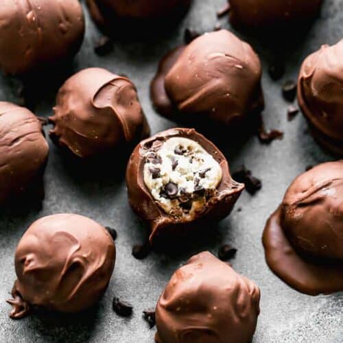 Cookie Dough Truffles on a plate and one with a bite taken from it.