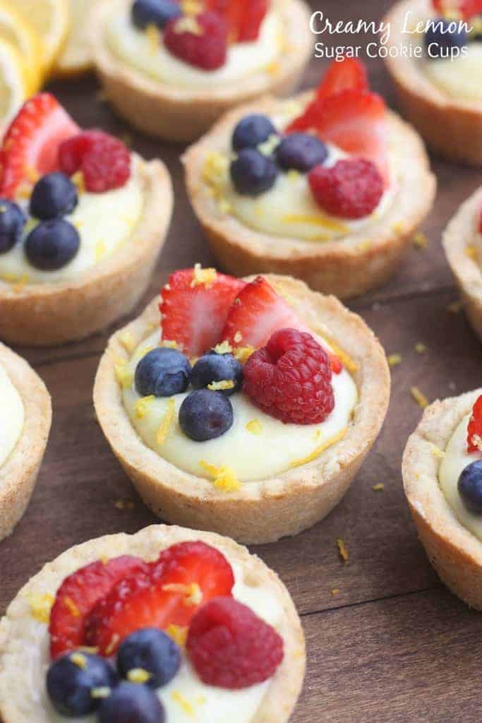 Creamy Lemon Sugar Cookie Cups - my favorite sugar cookie recipe baked in a muffin tin and filled with creamy lemon pie filling. Topped with fresh fruit. A beautiful and easy dessert that will impress your guests!