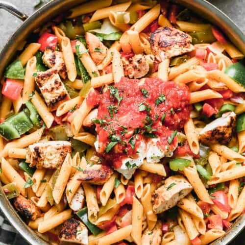 Chicken Fajita Pasta served in a skillet with a scoop of salsa on top.