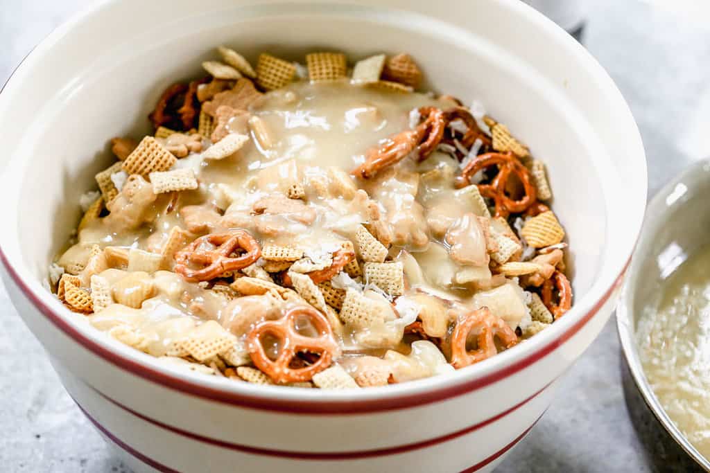 A serving bowl with sweet chex mix, with the candy syrup just poured on. 