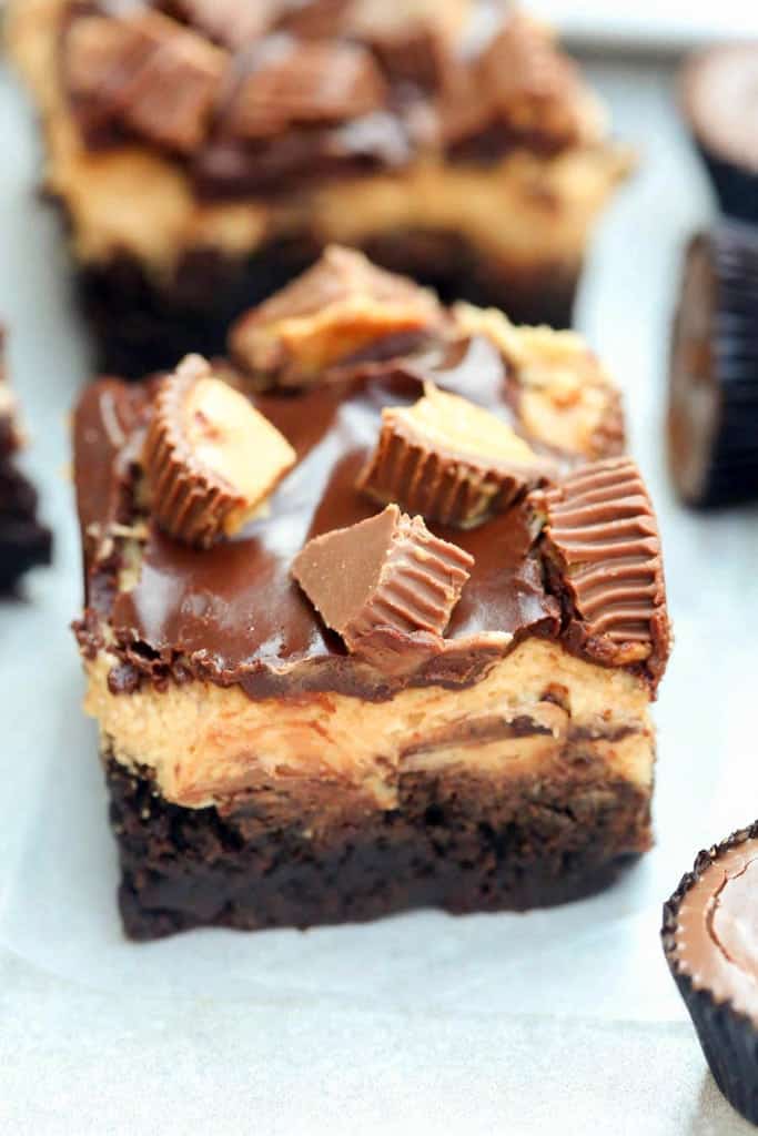 Reese's Peanut Butter Brownies are a chocolate and peanut butter lover's dream! Chewy homemade brownies with an amazing smooth peanut butter frosting. Topped with chocolate glaze and mini reese's cups. - Tastes Better From Scratch