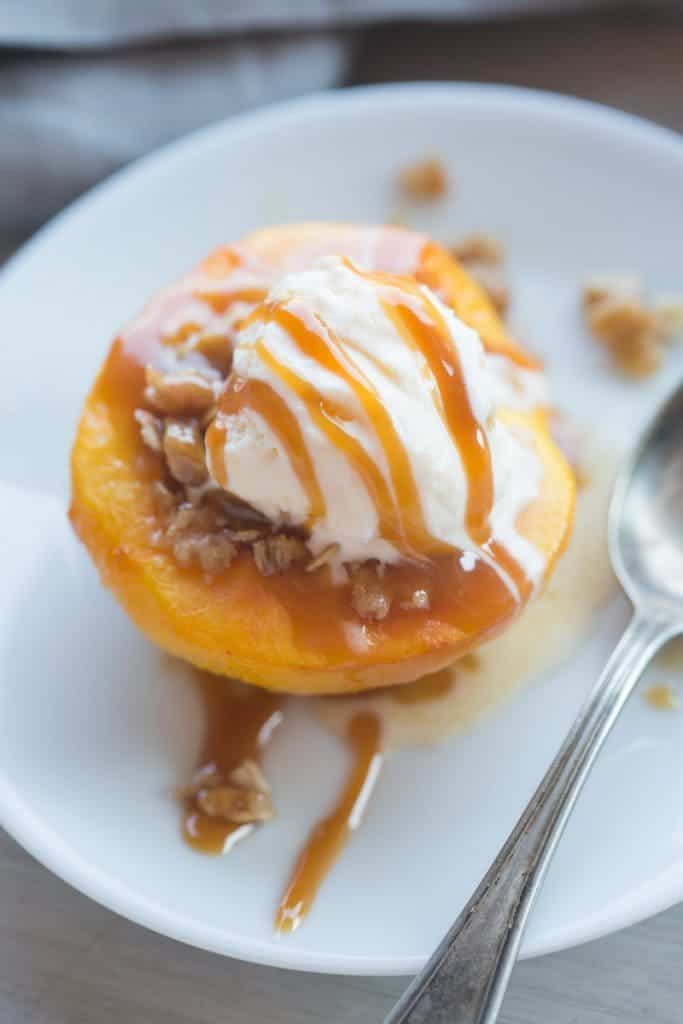 Warm and juicy baked peaches with a caramel oat crumble and vanilla ice cream! Baked peaches make the perfect light, warm and easy dessert!