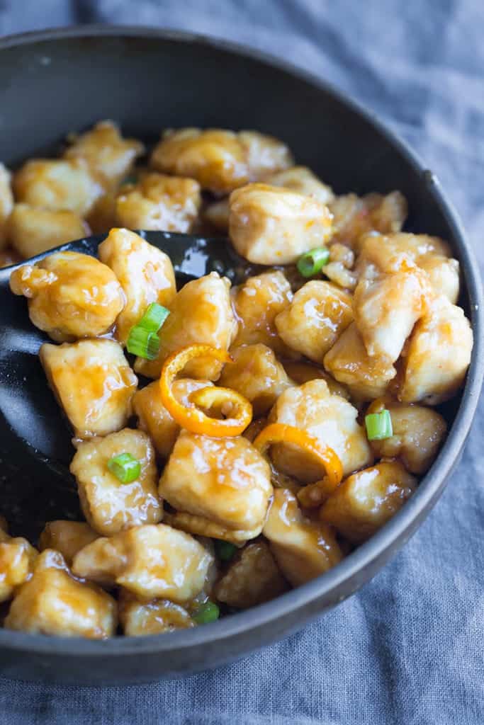 A bowl filled with orange peel chicken.