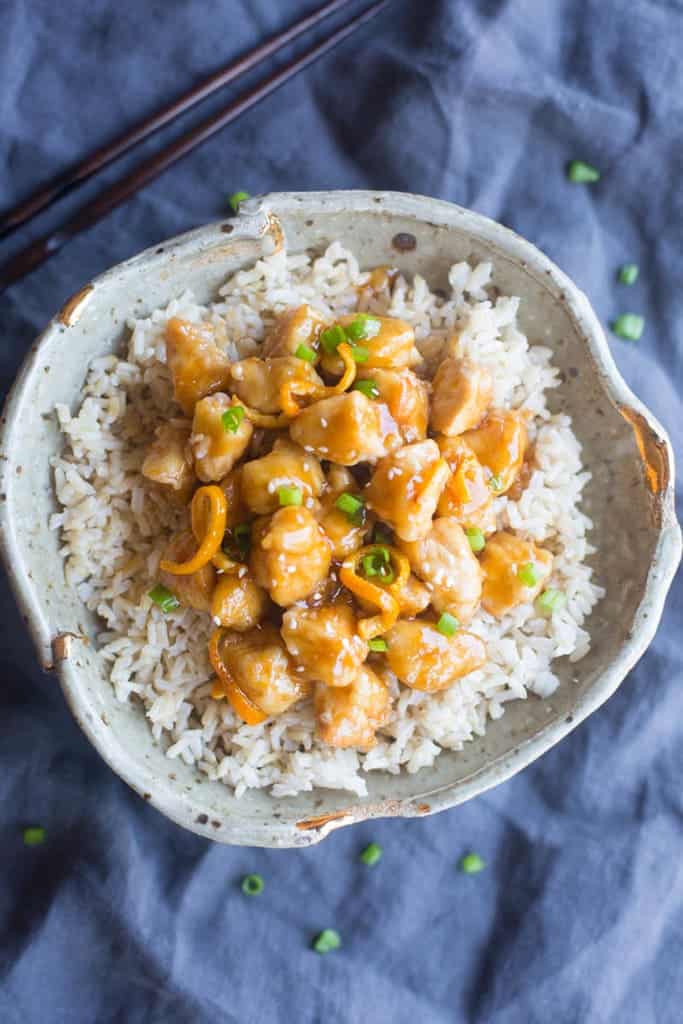 A serving of homemade orange chicken over brown rice.