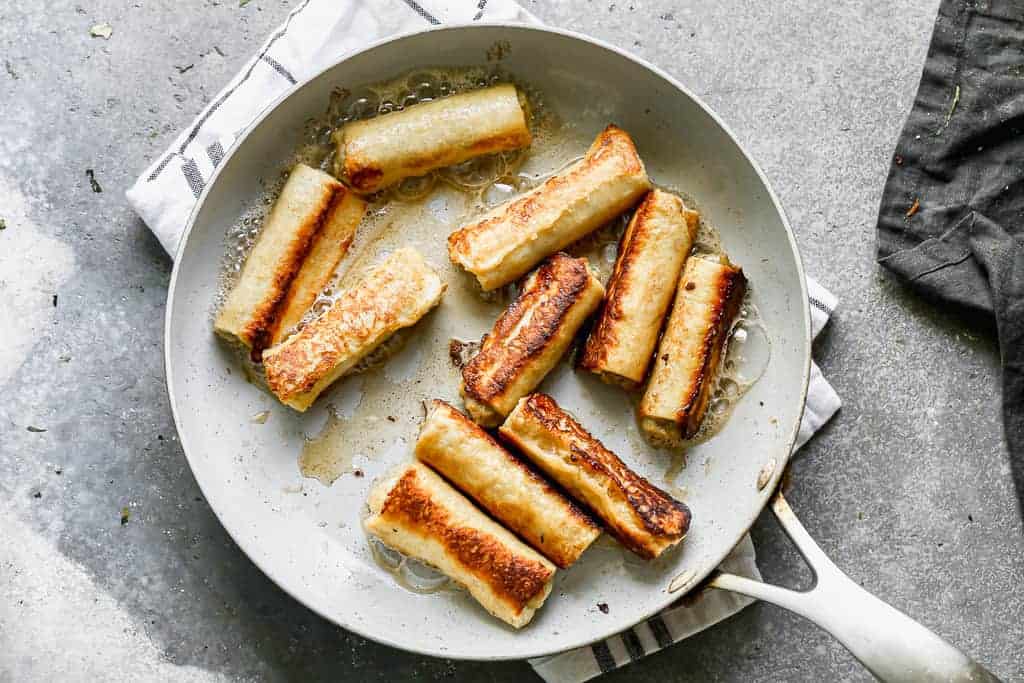 French toast roll-ups cooking in a skillet.