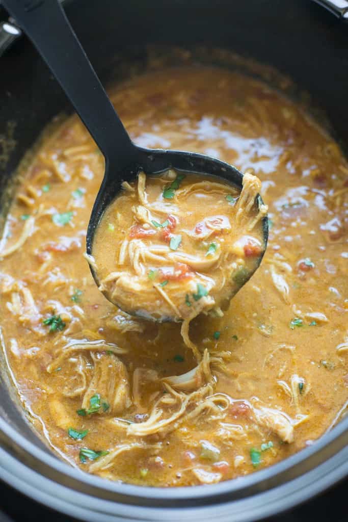 King Ranch Chicken Soup in a slow cooker with a ladle.