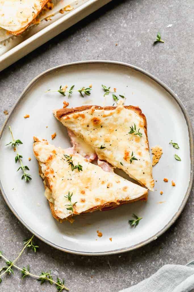 Croque monsieur sandwich cut in half and served on a plate.