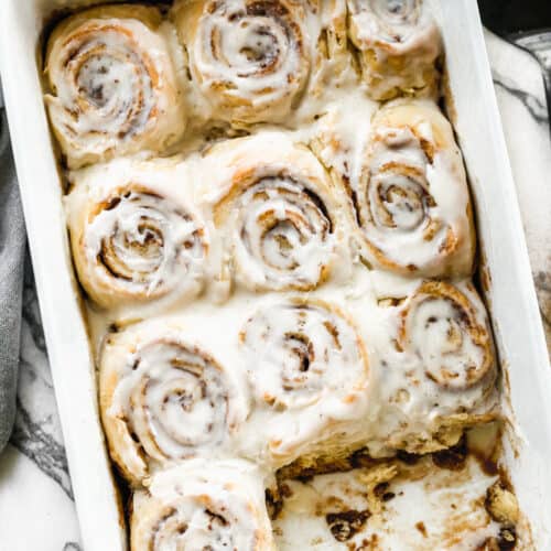 Cinnamon rolls baked in a 9x13 inch pan, with cream cheese frosting on top.