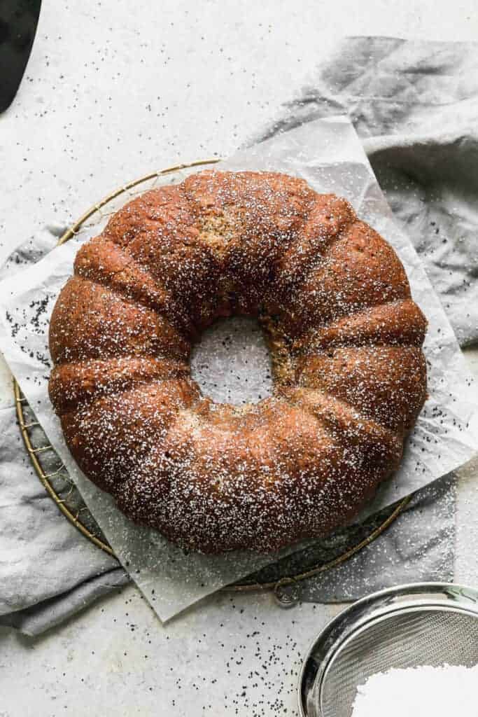 Overhead photo of a baked poppy seed cake dusted with powdered sugar.