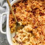 Baked Mac and Cheese in a casserole dish, hot from the oven, with a serving spoon in it.