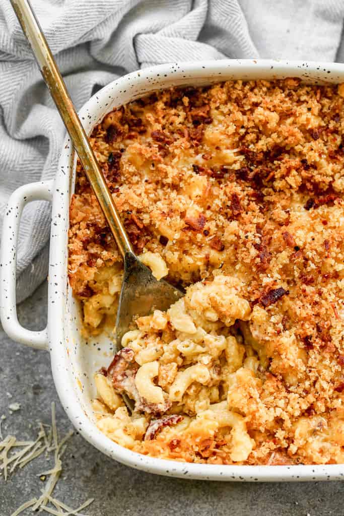Baked Mac and Cheese in a casserole dish, hot from the oven, with a serving spoon in it.