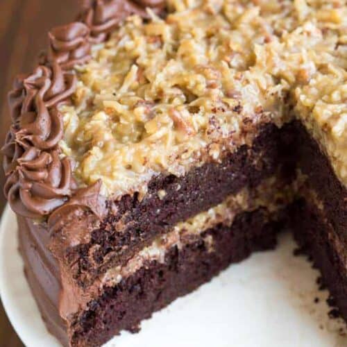 A double layer German Chocolate Cake with coconut pecan frosting, with a slice taken out of it.