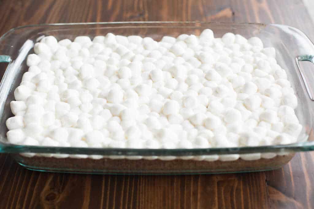 A 9x13 inch pan with brownies that are covered by miniature marshmallows.