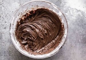 A mixing bowl with homemade chocolate frosting.