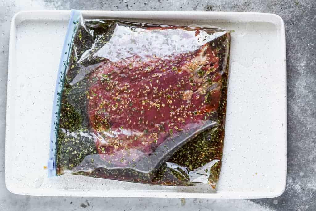 Flank Steak and steak marinade in a ziplock bag.
