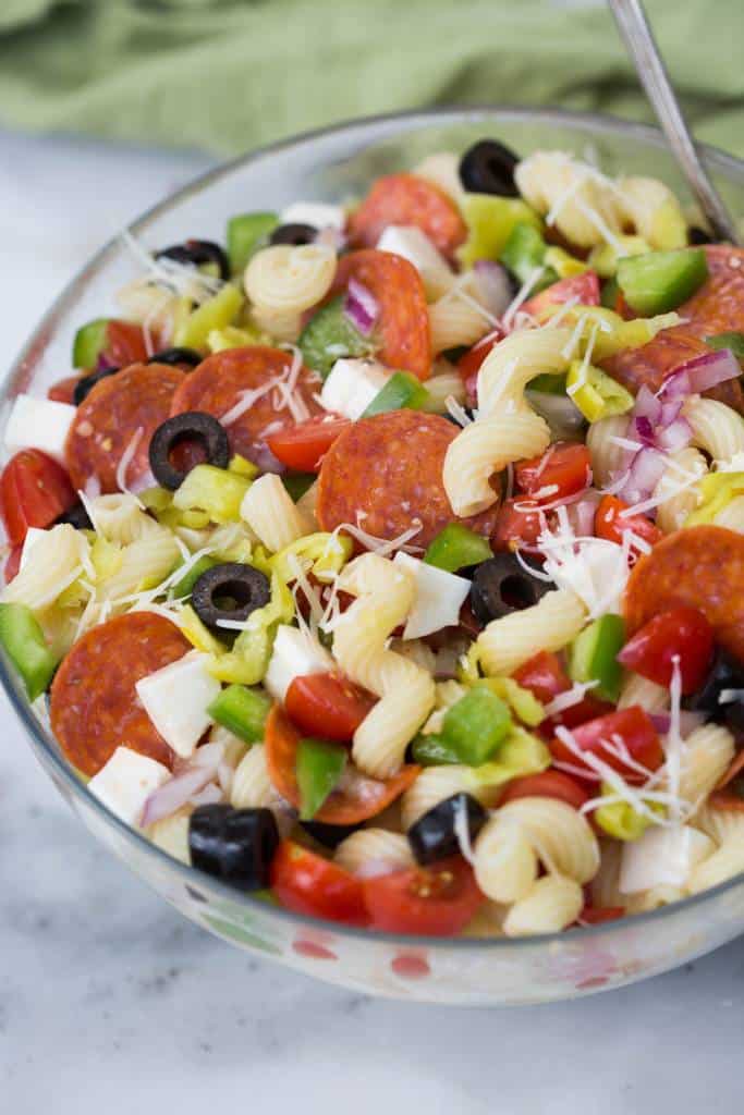 So much to love about this easy Pizza Pasta Salad loaded with pepperoni, olives, bell peppers, tomatoes, onion cheese and pepperocini | tastesbetterfromscratch.com