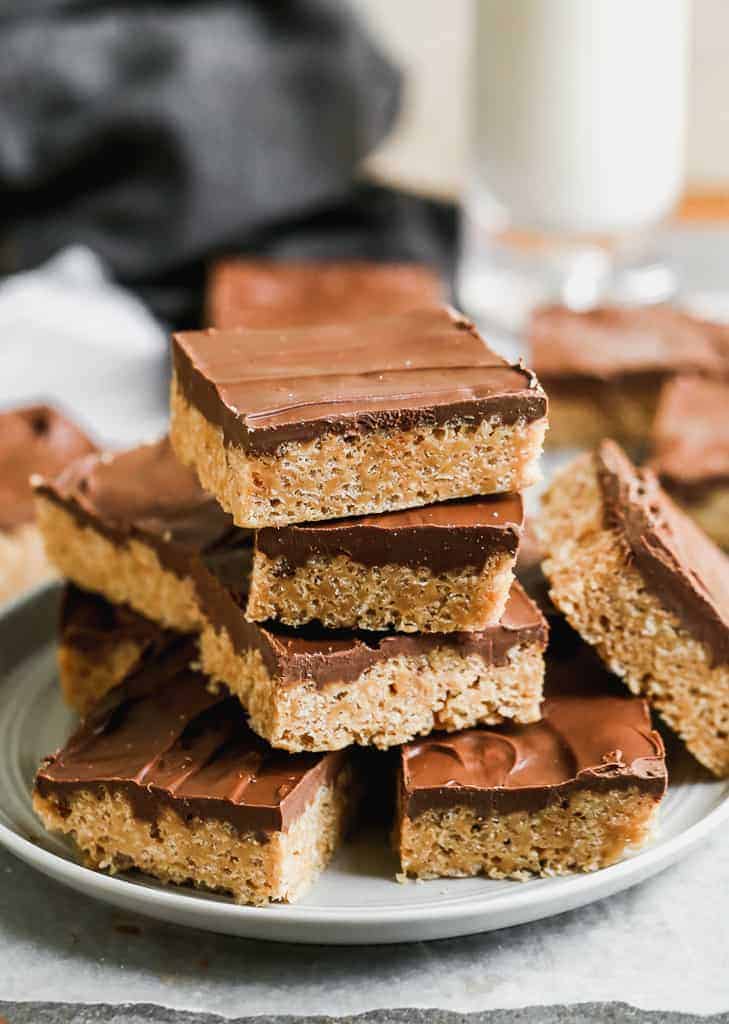 Scotcheroos bars stacked on a plate. 