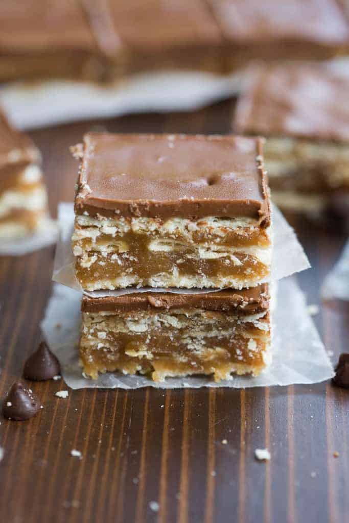 Two caramel crunch bars layered on top of one another with a piece of wax paper in between.